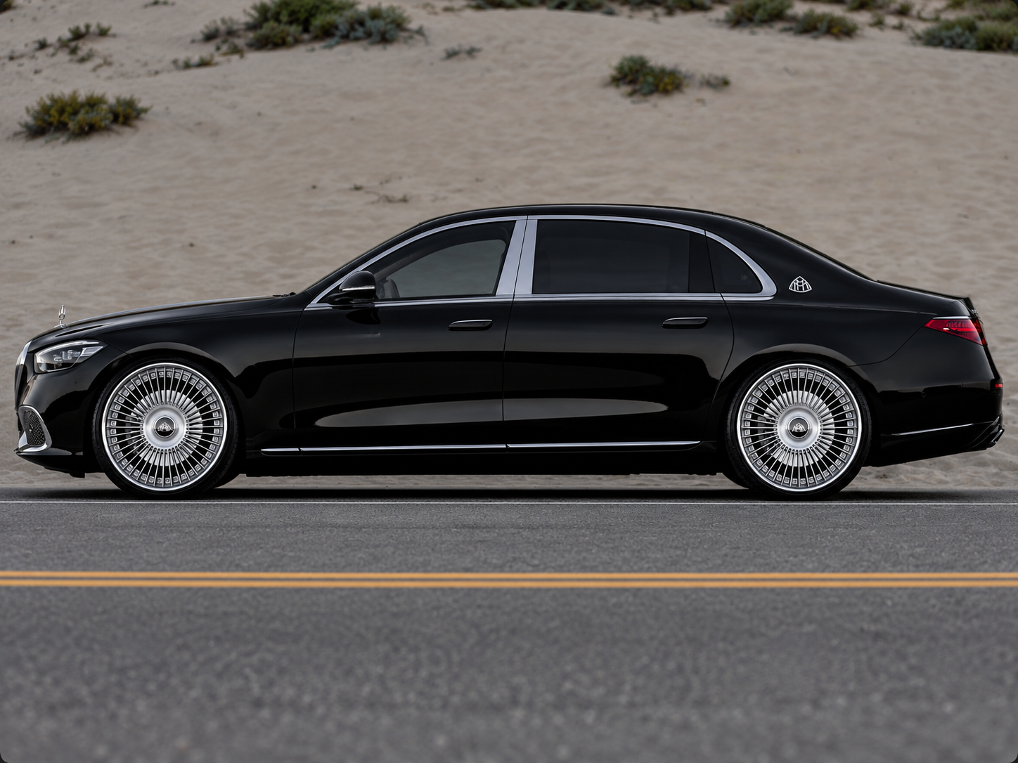 Black Maybach beside sandy dunes representing RAYNARY automotive window film